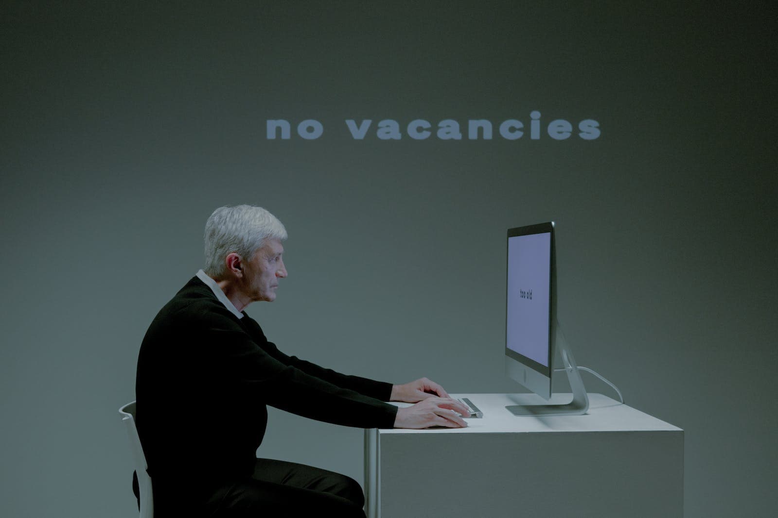 An Elderly Man with a Serious Face while using a Computer