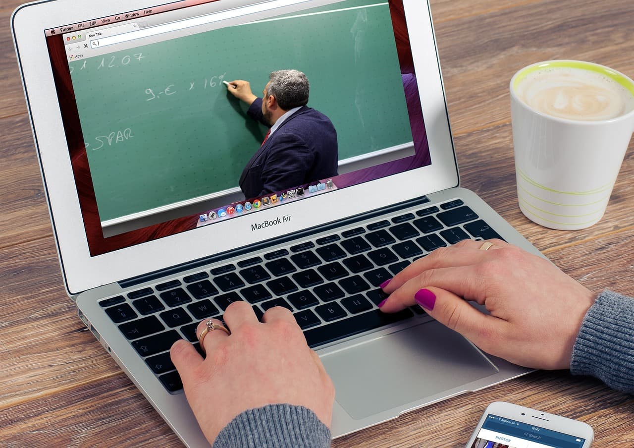 person following a webinar on the laptop