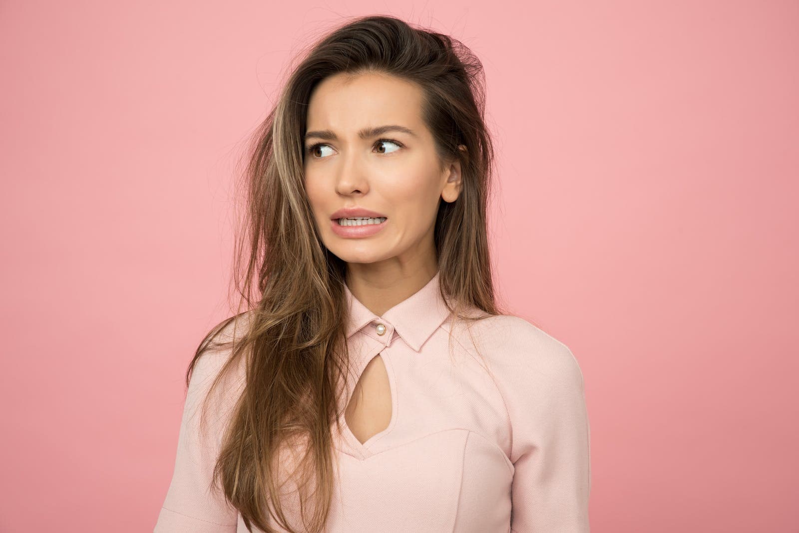 Woman Wearing Pink Top and an Insecure face