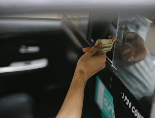 Interior of modern taxi car while passenger paying for ride
