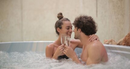 Happy couple having fun in jacuzzi during romantic date