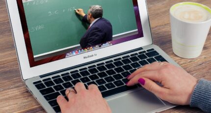 person following a webinar on the laptop