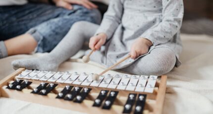 A Child Playing a Xylophone with Mallets