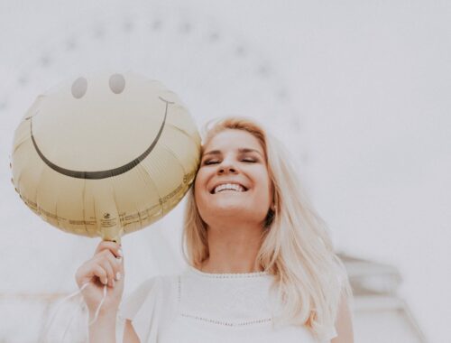 Woman Holding a Smiley Balloon