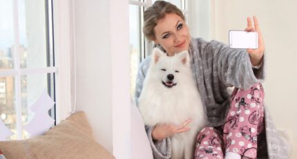 Woman Taking a Photo of Herself With White Dog