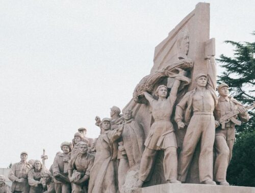 Stone Communist Monument with Crowd of People
