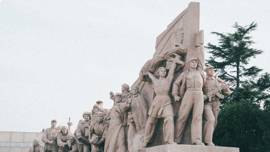 Stone Communist Monument with Crowd of People