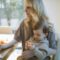 Photo Of Woman Carrying Her Baby While Working On Her Laptop