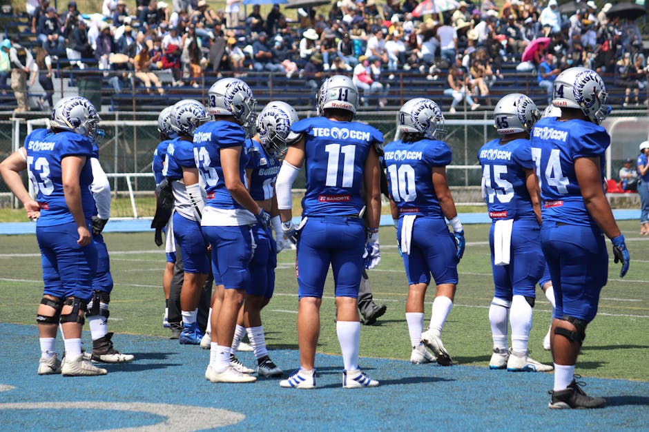 A group of football players standing on the field