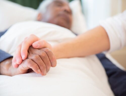 Young Persons Hand Holding an Old Persons Hand