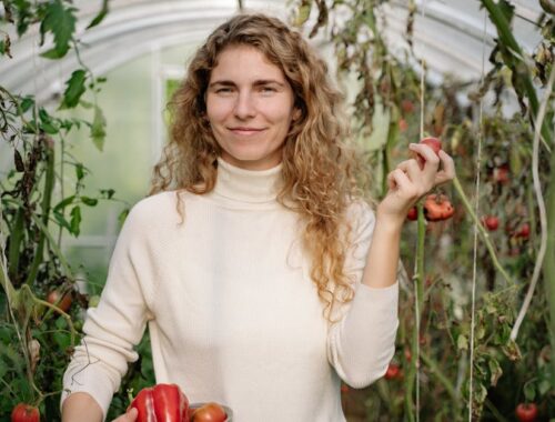 Close-Up Shot of a Woman in White Long Sleeves Holding a Bowl of Fruits