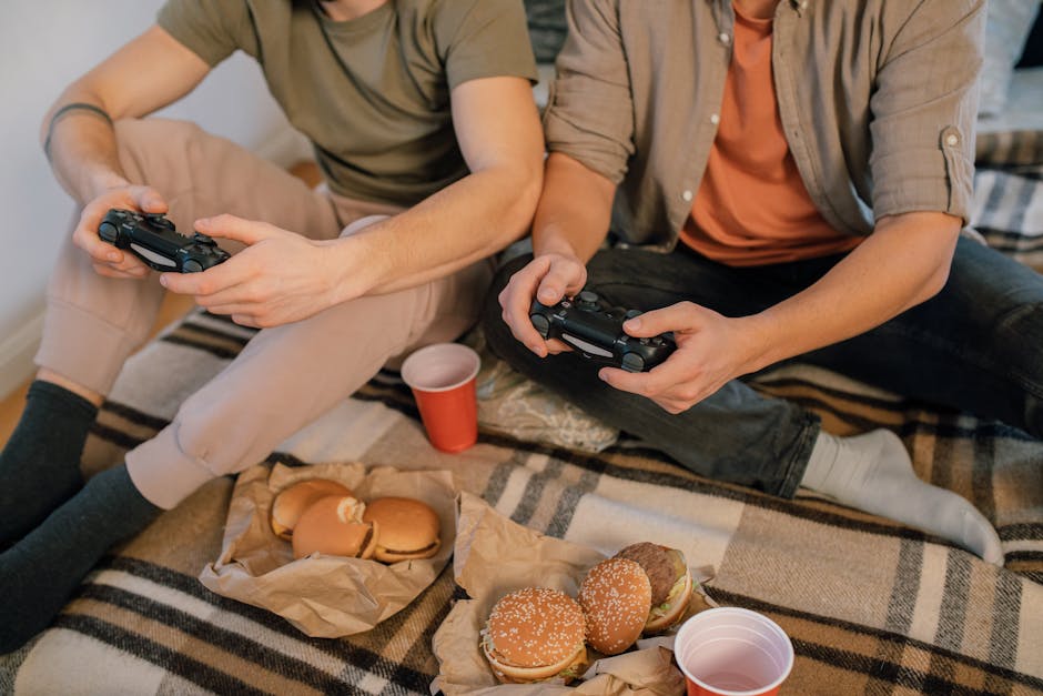 Photograph of Hands Using Video Game Controllers