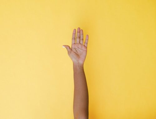 A Persons Left Hand on Yellow Background