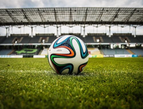 Multicolored Soccer Ball on Green Field