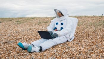 Man In A Space Suit Using Laptop